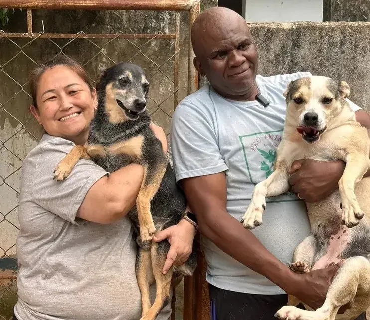 Voluntária abraçando um cão resgatado